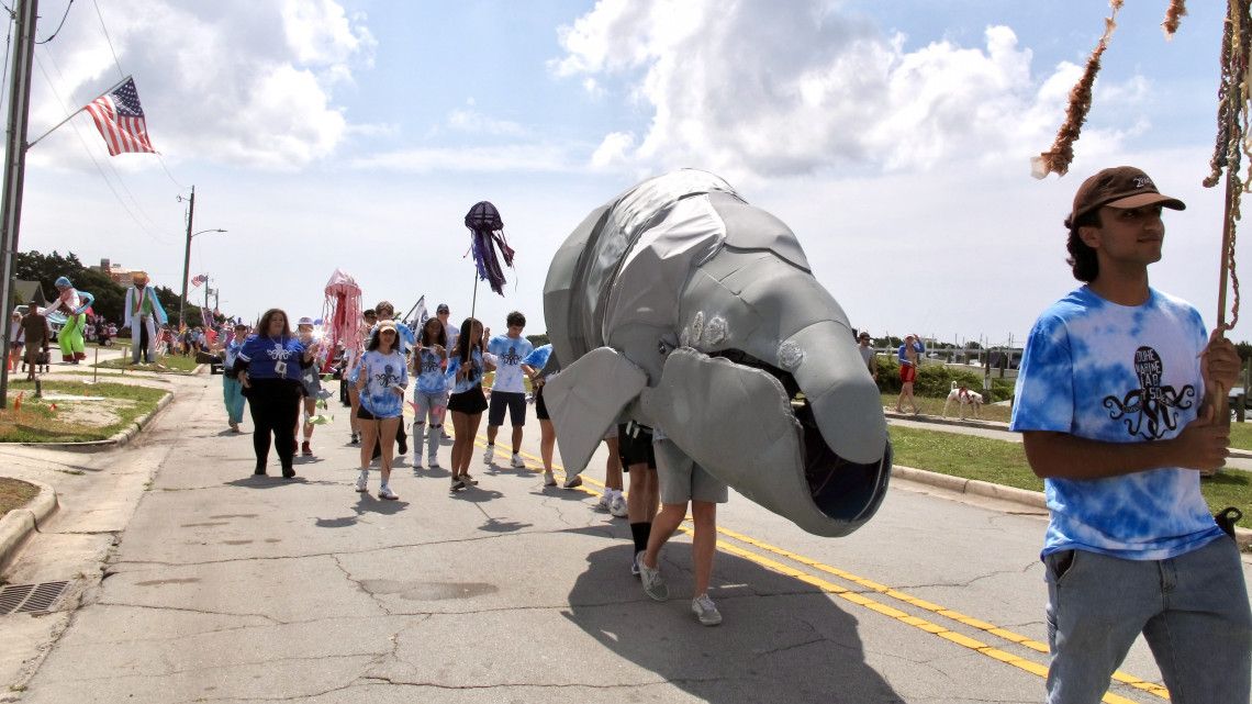 whale puppet and handlers march through parade
