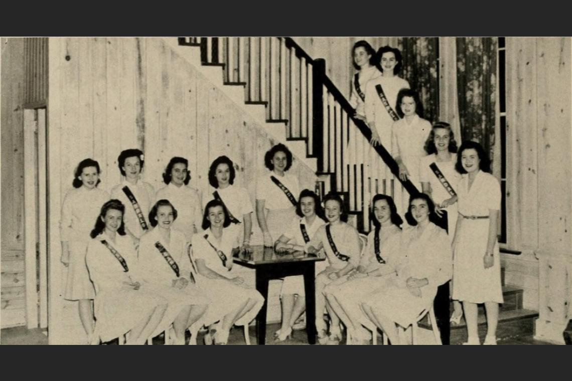 student hostesses posing on the Ark staircase in matching white dresses, in black and white photo